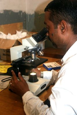Lab technician examines samples for suspected tuberculosis in ka